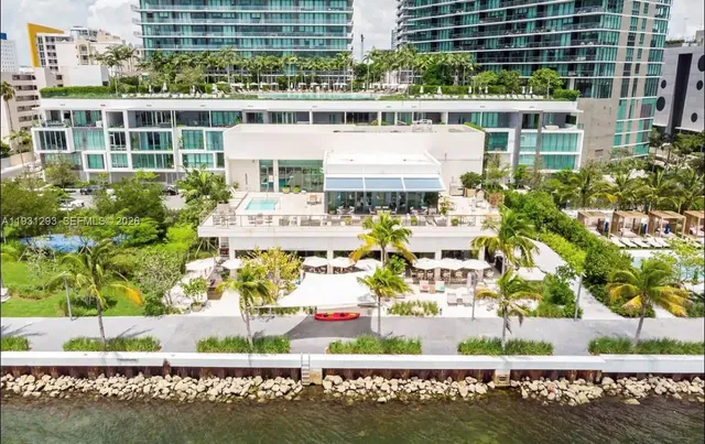 a aerial view of a residential apartment building with a yard and outdoor seating