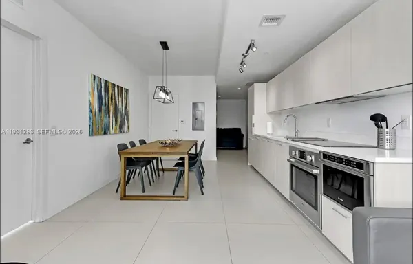 a kitchen with stainless steel appliances kitchen island hardwood floor and a sink