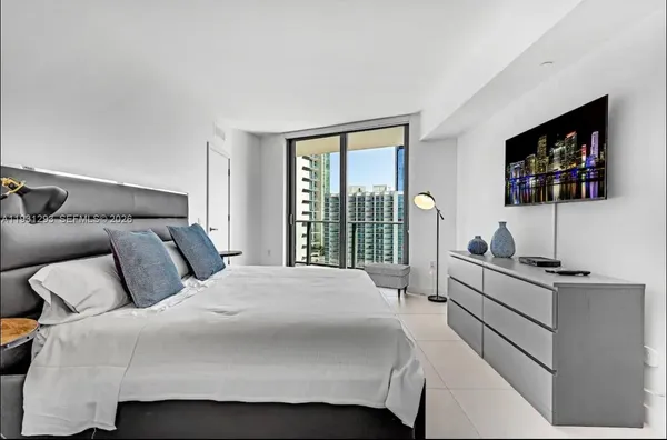 a bedroom with a bed and a flat screen tv