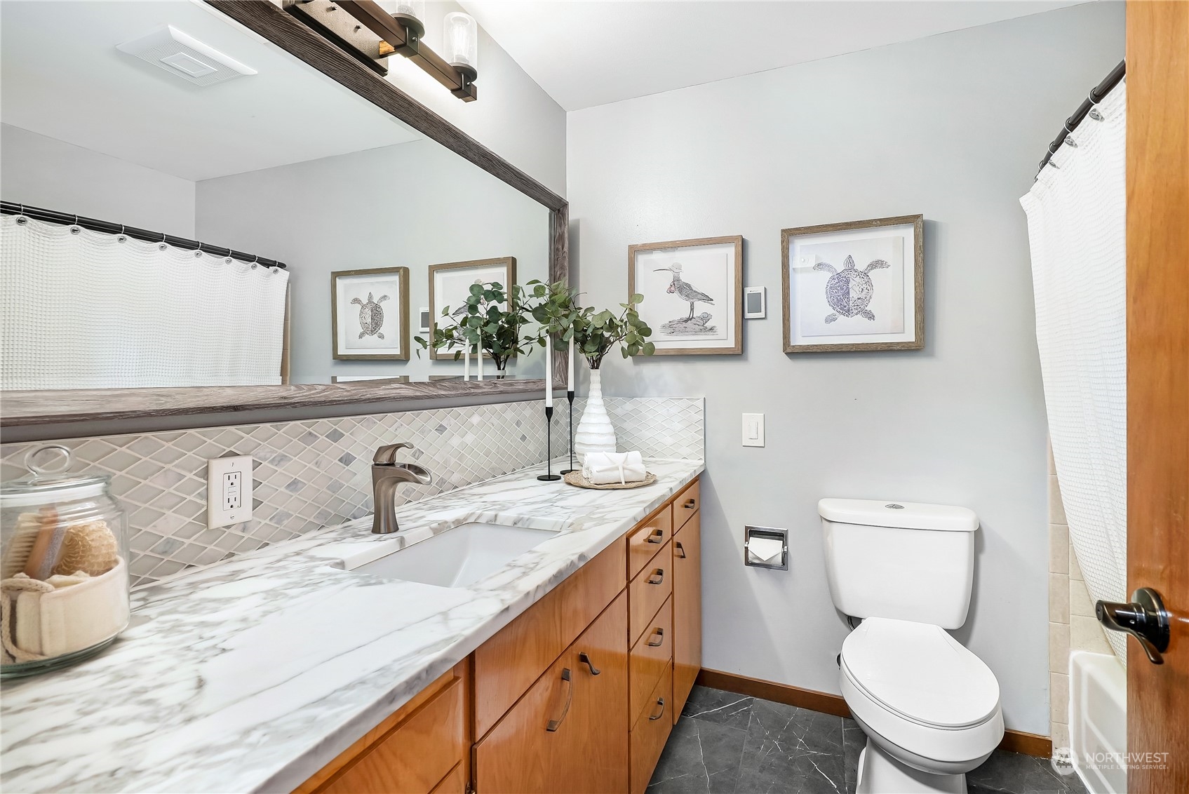 3112 Talbot Road South Renton, WA 98055 - Photo 12 of 29 a bathroom with a granite countertop toilet sink and mirror
