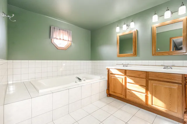 a bathroom with a sink a bathtub and a mirror