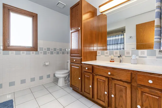 a bathroom with a double vanity sink a toilet and a mirror