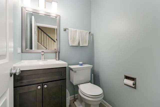 a bathroom with a toilet a sink and mirror