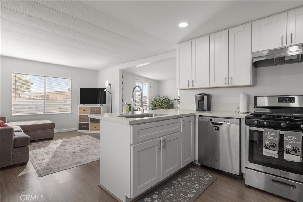 27150 Shadel Road, Unit 122 Menifee, CA 92586 - Photo 1 of 26 a kitchen with stainless steel appliances granite countertop a stove top oven a sink dishwasher and a refrigerator with wooden floor