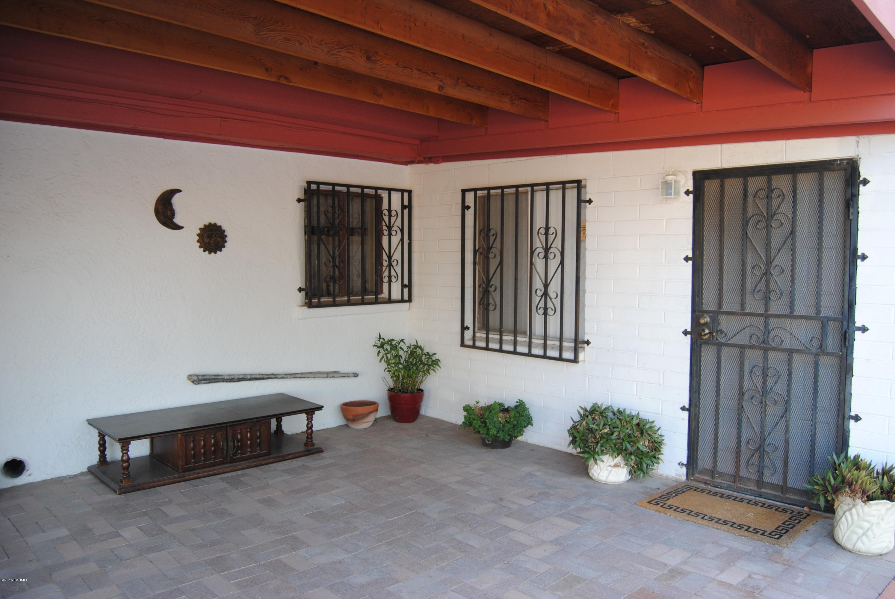 1607 West Roger Road Tucson, AZ 85705 - Photo 12 of 14 a front view of a house with entryway and potted plants