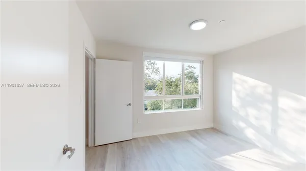 a view of a big room with wooden floor and windows