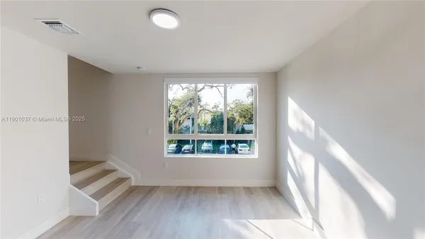 wooden floor in an empty room with a window