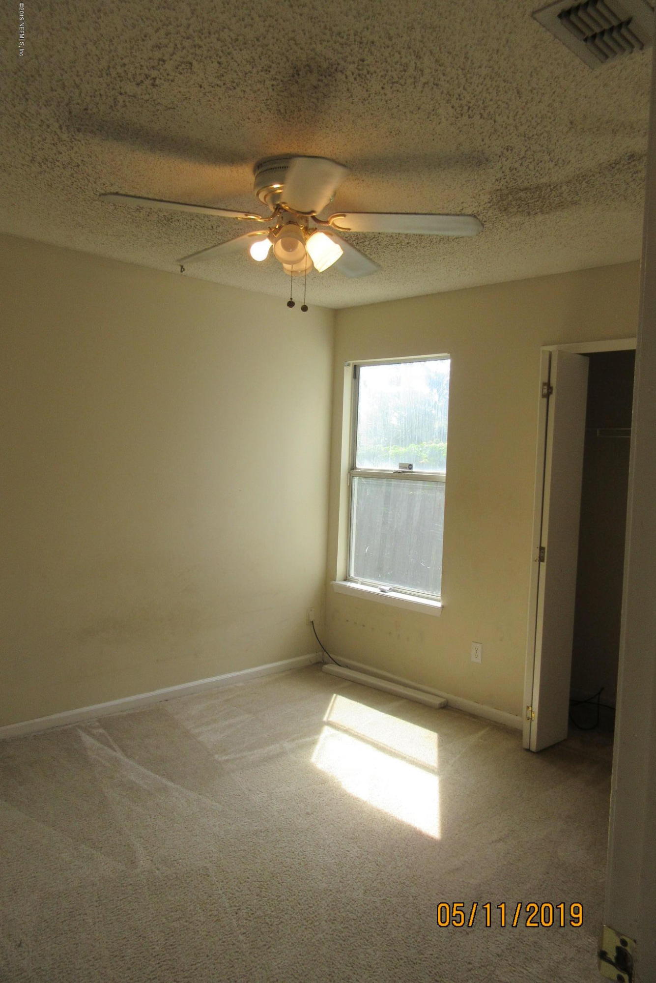 2465 Spring Vale Road Jacksonville, FL 32246 - Photo 8 of 11 en empty room with windows and chandelier fan