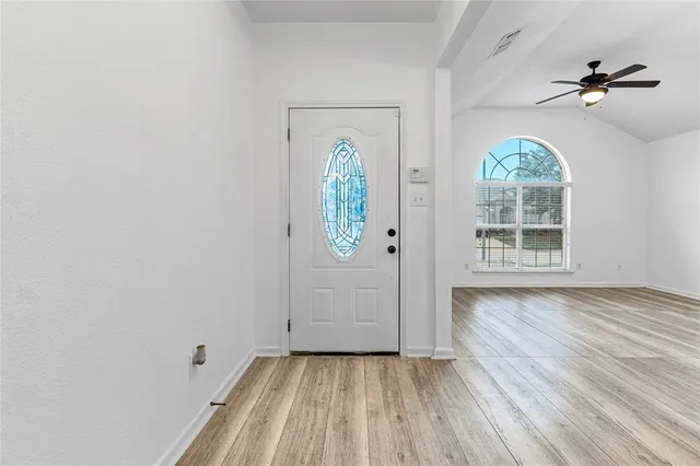 an empty room with windows and wooden door