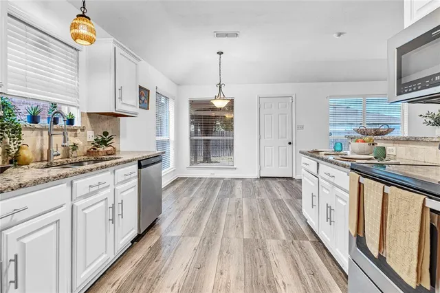 a kitchen with kitchen island granite countertop wooden cabinets and white appliances