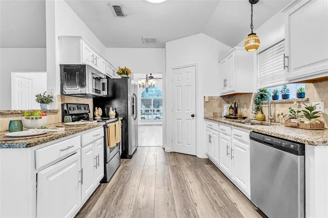 a kitchen with stainless steel appliances granite countertop a lot of counter top space and cabinets