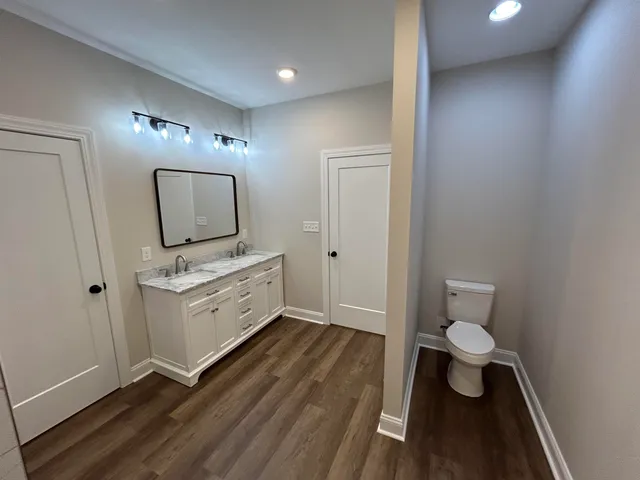 a bathroom with a toilet sink and mirror