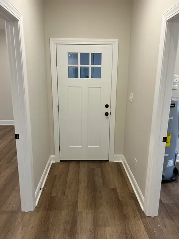 an empty room with wooden floor and entrance