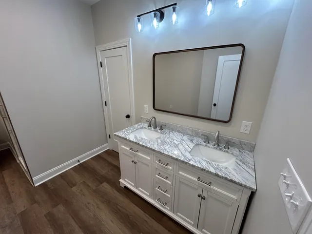 a bathroom with a granite countertop sink and a mirror