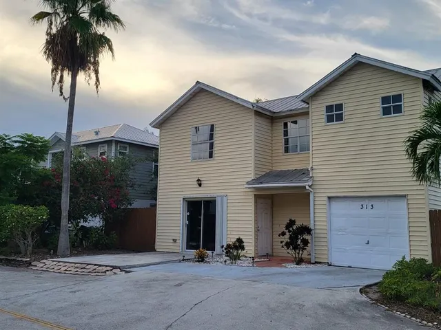 front view of a house with a potted plant and a yard