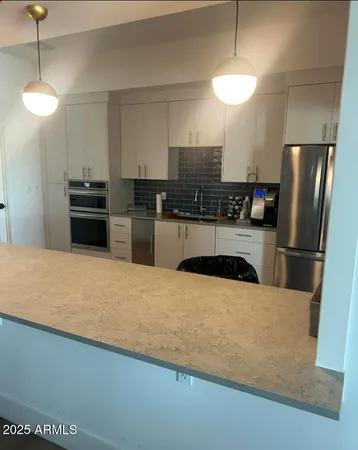 a kitchen with stainless steel appliances a refrigerator a stove a sink and a refrigerator