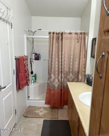 a bathroom with a granite countertop sink and a shower curtain