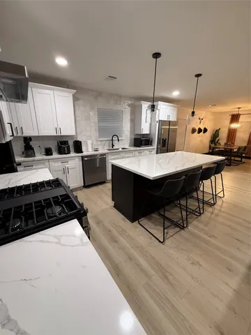 a kitchen with a table chairs stove and cabinets