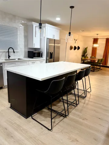 a kitchen with refrigerator cabinets and wooden floor