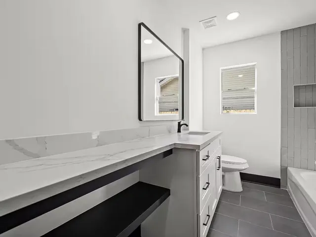 a bathroom with a sink a toilet and mirror