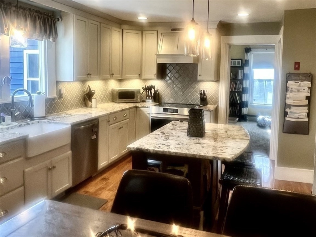 a kitchen with a table chairs refrigerator and stove