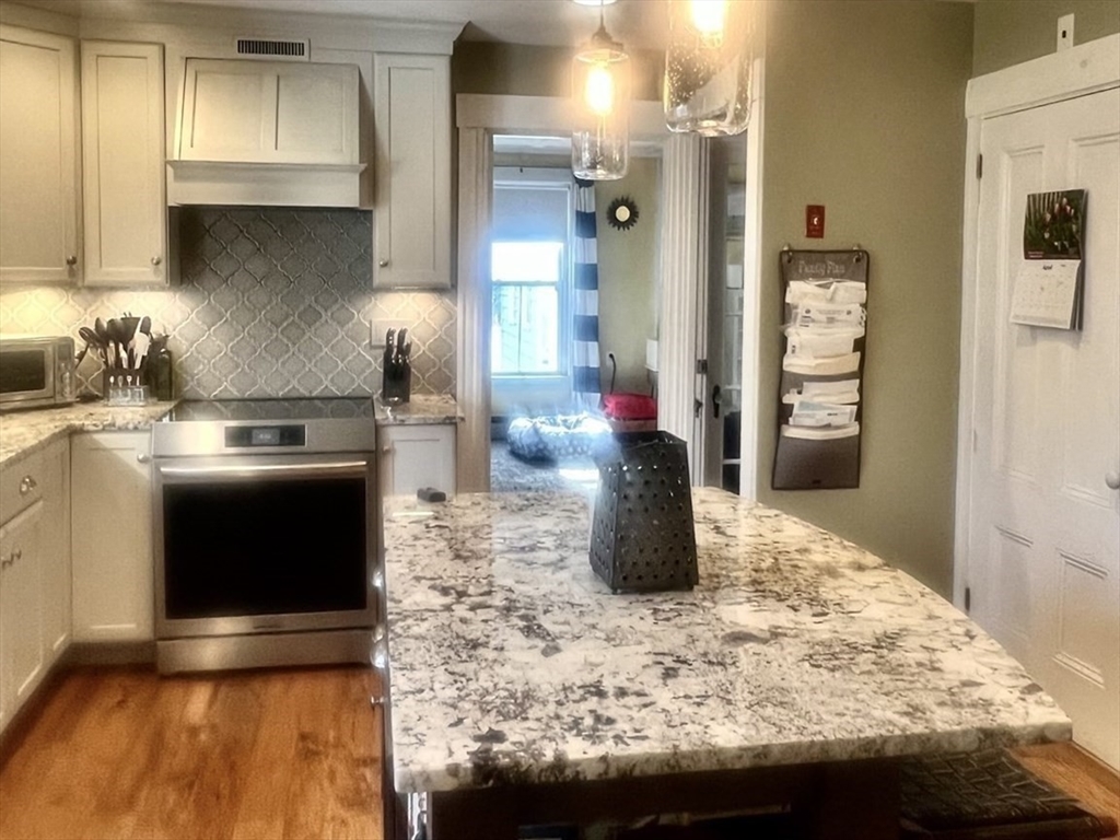 131 Pleasant Valley Street Methuen, MA 01844 - Photo 11 of 23 a kitchen with a stove and a refrigerator