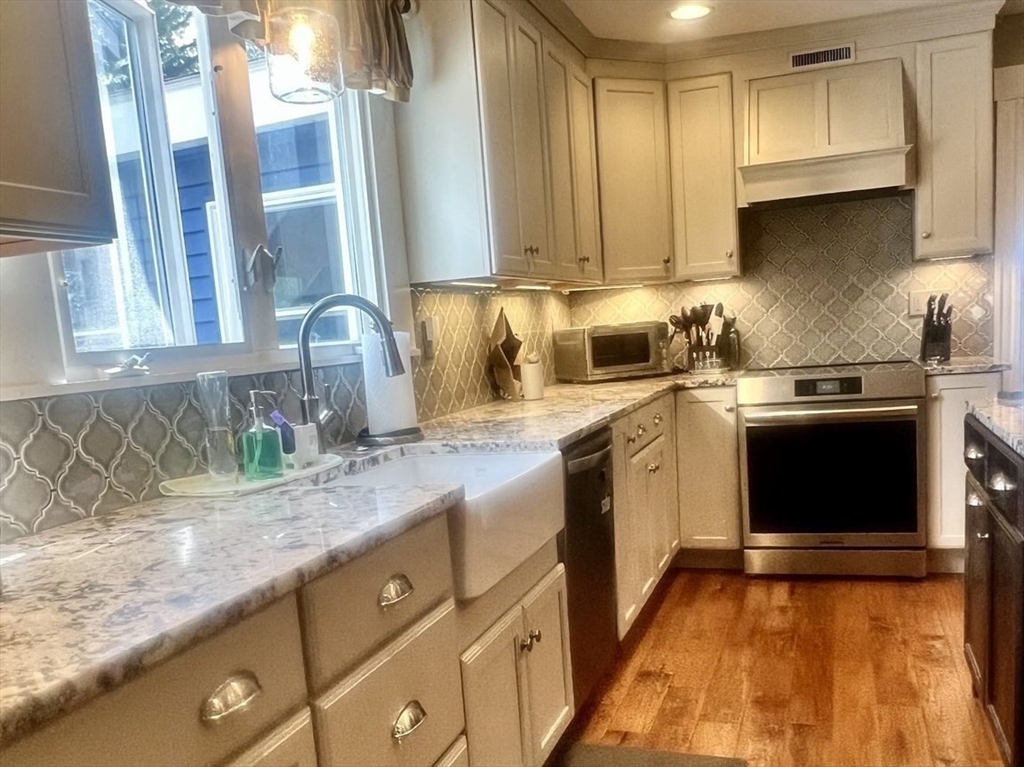 131 Pleasant Valley Street Methuen, MA 01844 - Photo 9 of 23 a kitchen with stainless steel appliances granite countertop a stove a sink and a microwave