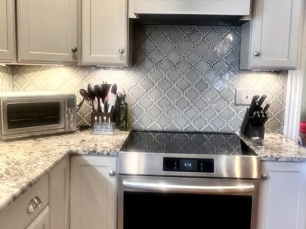 131 Pleasant Valley Street Methuen, MA 01844 - Photo 10 of 23 a kitchen with a stove and a microwave