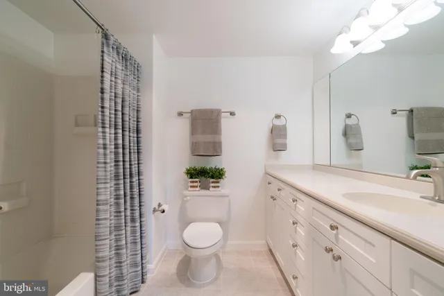 a spacious bathroom with a granite countertop sink a toilet and shower