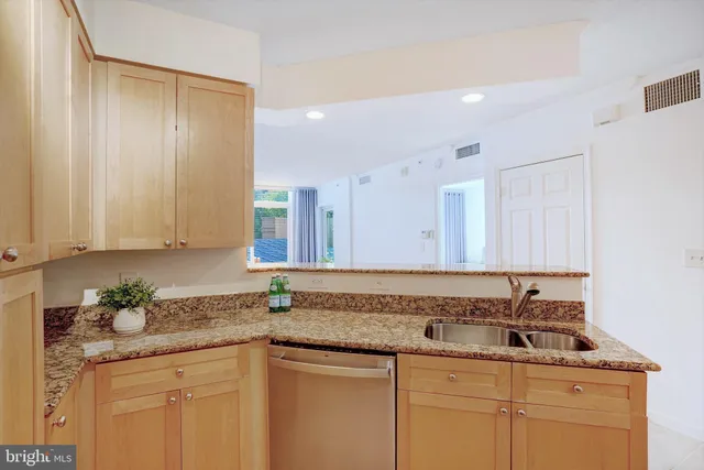 a kitchen with granite countertop a sink and cabinets