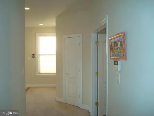a view of an empty room with closet and a window