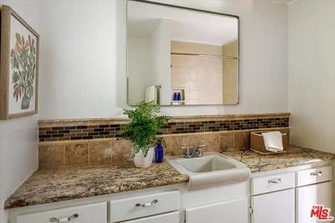 a bathroom with a granite countertop sink and a mirror