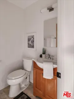 a bathroom with a toilet a sink and mirror