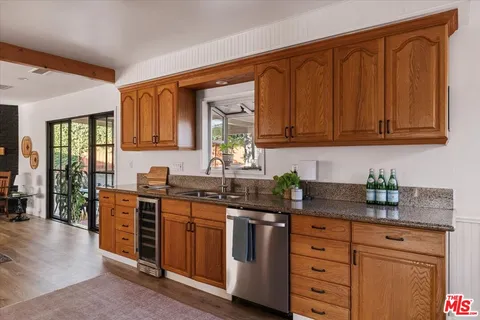 a kitchen with stainless steel appliances granite countertop a stove a sink dishwasher and cabinets with wooden floor