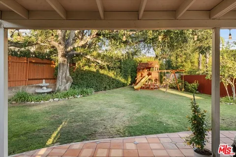 a view of a patio with table and chairs under an umbrella