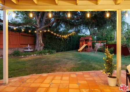 a view of a house with backyard and sitting area