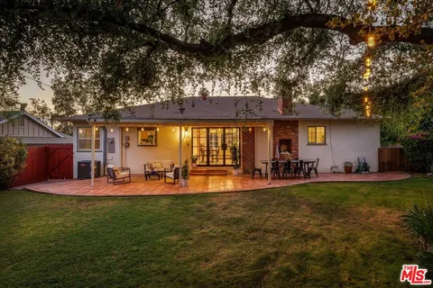 a front view of a house with a yard and mountain view in back