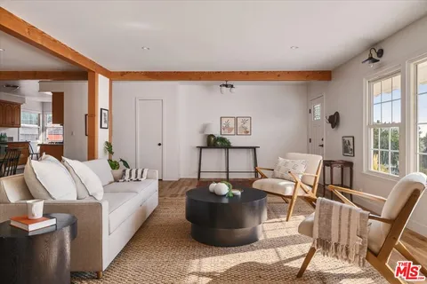 a living room with furniture a rug and a large window