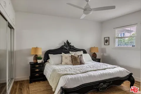 a bedroom with a bed and wooden floor