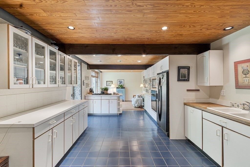 49 Thissell Street Beverly, MA 01915 - Photo 11 of 36 a large white kitchen with stainless steel appliances granite countertop a stove and a sink