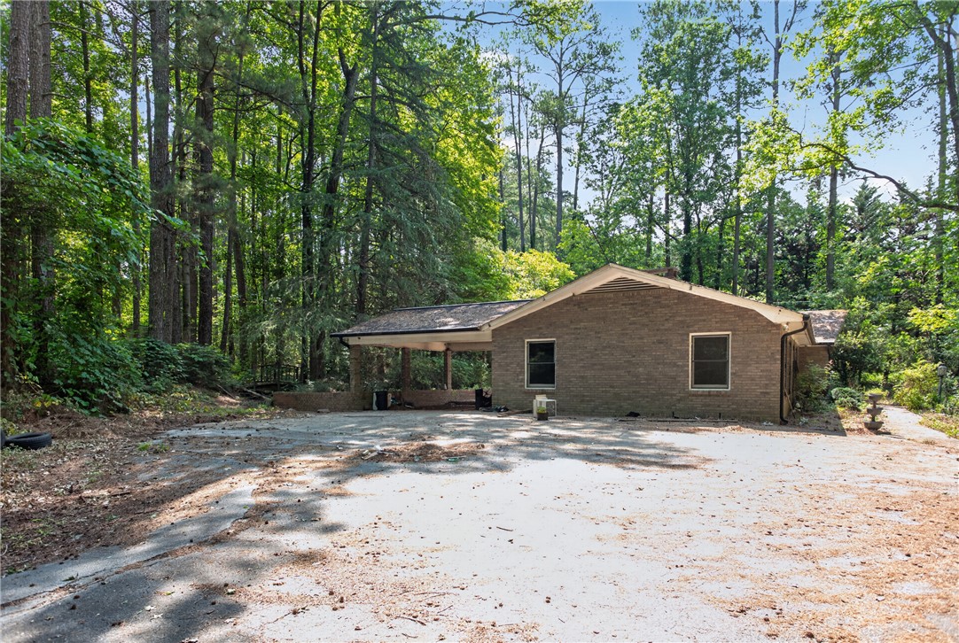 123 Robin Road Westminster, SC 29693 - Photo 3 of 50 Mature trees envelop this brick residence, offering privacy and a spacious driveway.