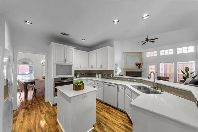 a kitchen with stainless steel appliances a table chairs refrigerator and microwave