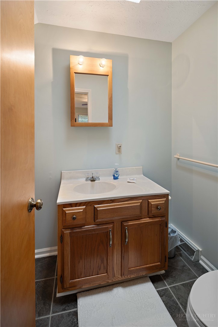 265 Leatherwood Road Banner Elk, NC 28604 - Photo 27 of 42 a utility room with a sink a toilet and mirror