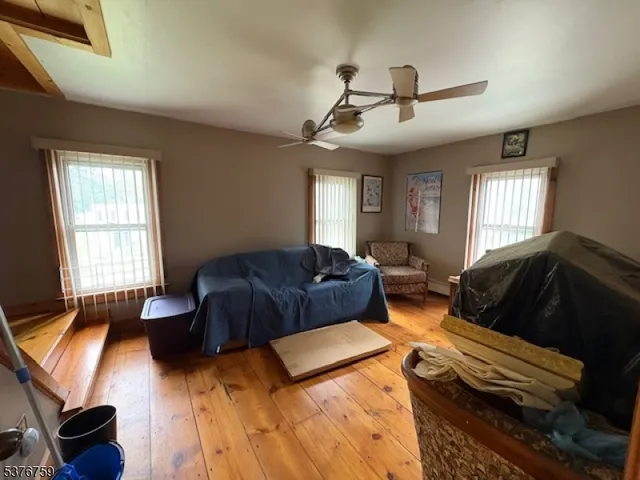 a bedroom with a bed ceiling fan and a window