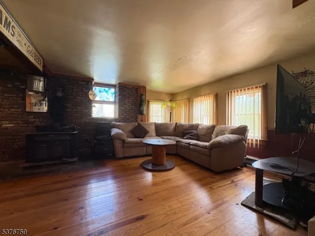 a living room with furniture a flat screen tv and wooden floor