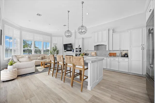 a kitchen with white cabinets stainless steel appliances and dining table