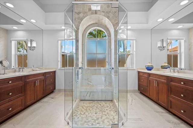 a spacious bathroom with a granite countertop sink a mirror and a shower