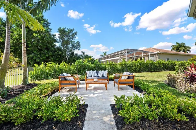 a view of a garden with lawn chairs under an umbrella