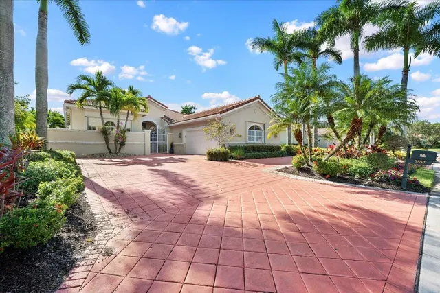 a front view of a house with a yard and potted plants