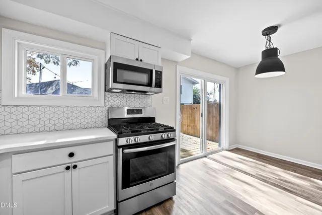 a kitchen with stainless steel appliances a stove microwave and sink